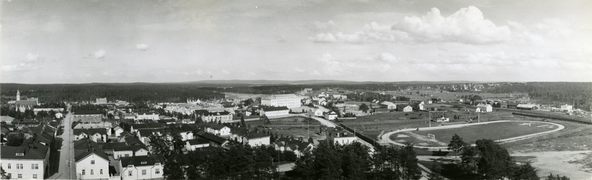 Mustavalkoinen ilmakuva Kajaanissa, jossa näkyy muun muassa Lönnrotin Koulu.